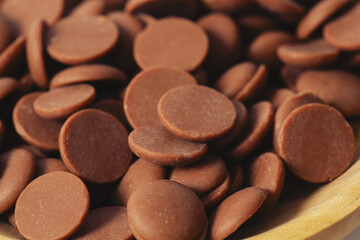 Tasty chocolate morsels isolated on white background.