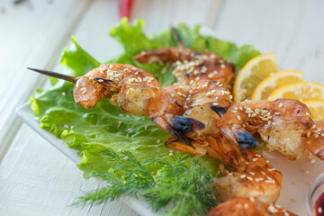 shrimp kebab on a plate over a table