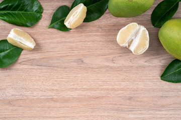 Fresh pomelo fruit on bright wooden table background.