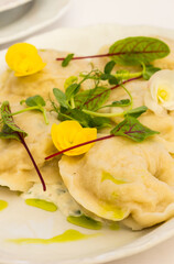 Traditional boiled Polish meat dumplings, served with sour cream and decorated with yellow flowers
