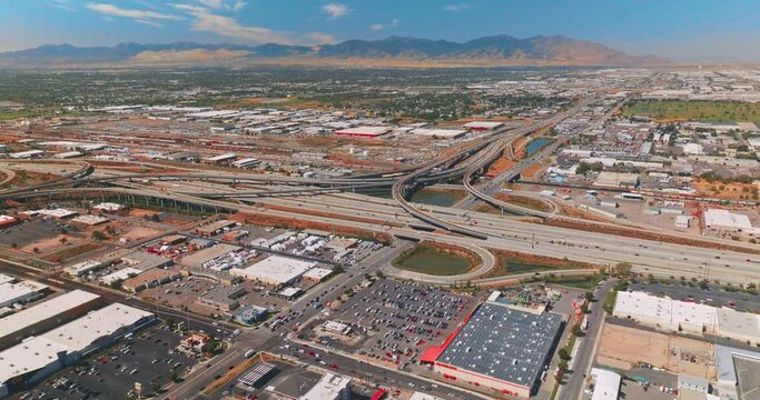 Big parking lots and complicated roads at the outskirts of Salt Lake City. Mountains of Utah at backdrop. Top view.