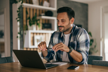 Obraz premium Focused adult man having a business meeting, using a laptop, at