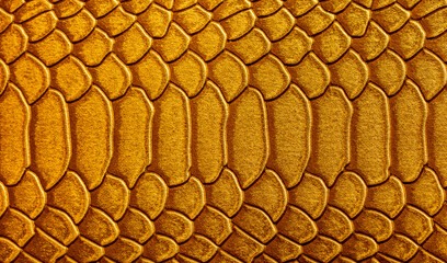 Beautiful yellow, gold bright snake or crocodile skin, reptile skin texture, multicolored close-up as a background.