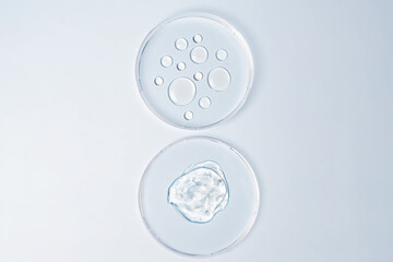 Transparent drops of cosmetic product serum gel in petri dish. Liquid texture with bubbles on blue...
