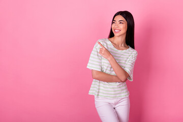 Portrait of cheerful pretty thai girl look direct finger empty space blank isolated on pink color background