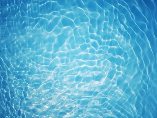 Bluewater waves on the surface ripples blurred. Defocus blurred transparent blue colored clear calm water surface texture with splash and bubbles. Water waves with shining pattern texture background.