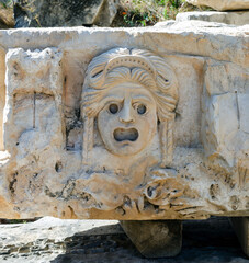 Historical stone theatrical masks bas relief of amphitheater at ancient city Myra. Territory of modern Demre city, Antalya province, Turkey