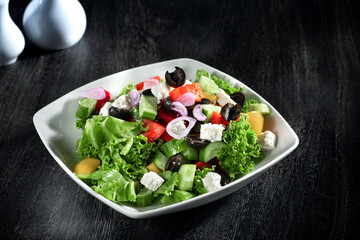 Close up view of Greek salad on dark grey background