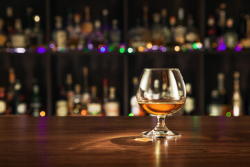 view of glass of  cognac on brown color wooden table surface