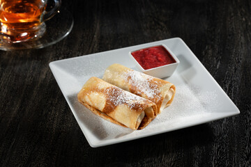 close up view of nice yummy crepes with jam on grey table