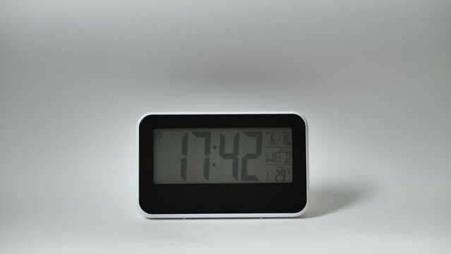 Modern mirror clock, alarm clock with a thermometer, hydrometer standing on white background. Time concept.