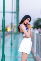 Portrait of beautiful athletic young asian woman in fashionable sportswear standing and having rest after exercise training on Route walking jogging or ride bicycle and exercise on the bridge.