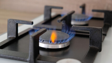 Close-up blue flames of fire on a gas burner in the kitchen for cooking. Gas flame in a gas boiler