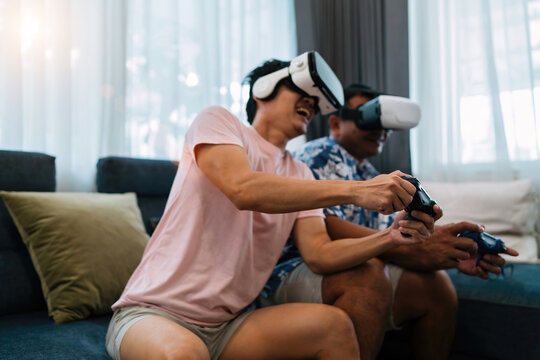 excited happy friends play vr glasses. future gaming technology device make male players enjoy competitive each other for fun. brothers wearing innovation virtual reality headset join in cyber world - Powered by Adobe