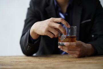 Businessman handshake after make deal, alcoholism, alcohol addiction and people concept - male alcoholic with glass of whiskey lying or sleeping on table 