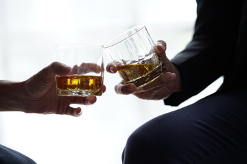 Businessman handshake after make deal, alcoholism, alcohol addiction and people concept - male alcoholic with glass of whiskey lying or sleeping on table 