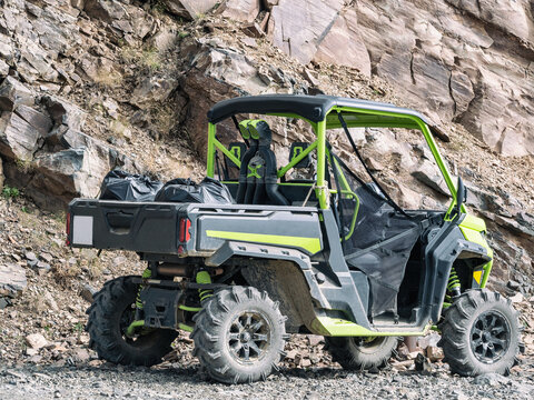 All-terrain four-wheeler vehicle. Off-road quad at rock background