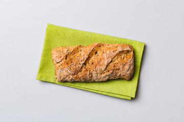 Fresh loaves of bread with wheat and gluten on a colored table. bread on napkin on rustic background, fresh bread top view
