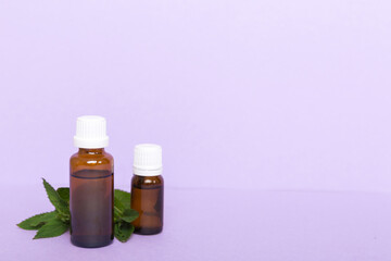 Natural Mint Essential Oil in a Glass Bottle. organic cosmetics with herbal extracts of mint on colored background