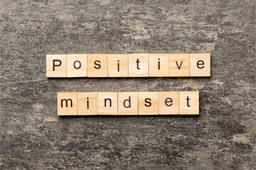 Fototapeta premium positive mindset word written on wood block. positive mindset text on cement table for your desing, concept