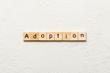 adoption word written on wood block. adoption text on table, concept