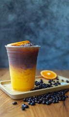 iced coffee drink menu Orange Americano fusion with fresh orange fruit mixed in a plastic cup, drink menu product.