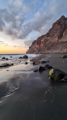 Scenic view during sunset on volcanic black sand beach Playa del Ingles in Valle Gran Rey, La...