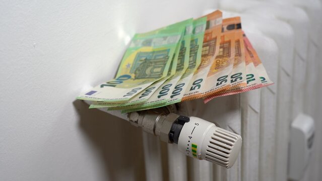 Europe, Italy , Increase in the cost of bill for  gas and electricity causes increased price for the procurement of raw materials, money 100, 50 euro banknote and domestic heating radiator