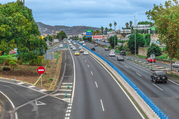 Tenerife, Spain - November 25, 2021: View of the Autopista del Norte highway from the bridge near Tenerife Norte Airport in the Canary Islands. High speed asphalt road with many cars and billboards