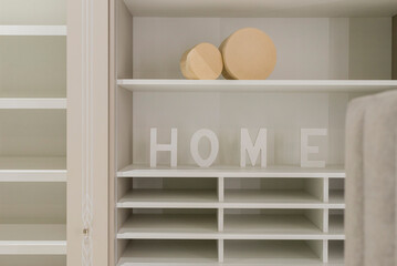 A light-colored wardrobe for things, shelves, two boxes and large letters: 