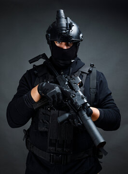 Attentive male warrior with rifle in dark room