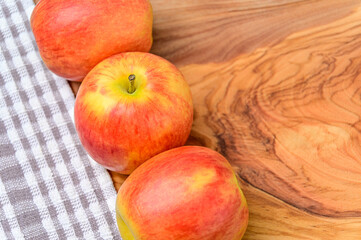 Three Apples on a wood and cloth background