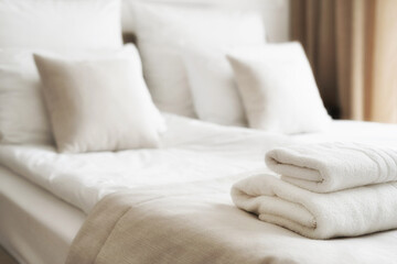White fresh towels on bed in hotel room - obrazy, fototapety, plakaty