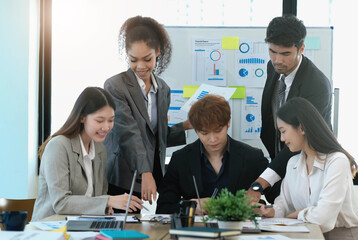 Asian business woman leader workers a paper business plan in a group meeting. Emphasis on female...