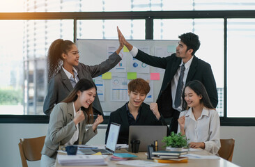 Group of Young Asian business team creative business people coworker in office Happy to be successful partnership teamwork celebrating achievement and Asian success concept.