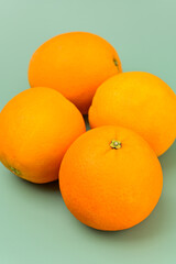 Four Whole Oranges on a Green background