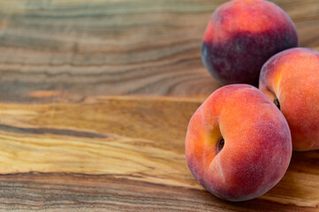 Three Peaches on a wood background with room for wording on the left