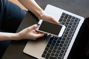 オフィスでスマホを操作する女性の手元