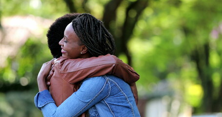 Two best friends meeting, African women hugging and embrace outside in street