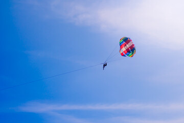 Parasailing in blue sky. Sports, active leisure, travel, vacation concept