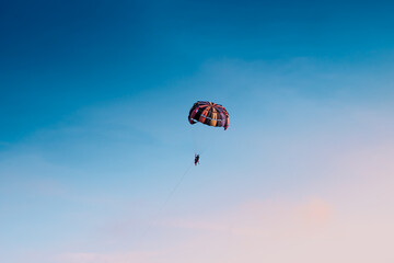 Parasailing in blue sky. Sports, active leisure, travel, vacation concept