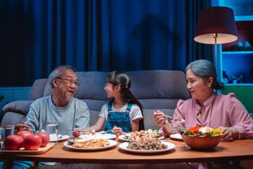Asian happy family having lunch on dinner japanese table smiling together. little kid daughter enjoy eating food grandparents. Happiness time people lifestyle concept.