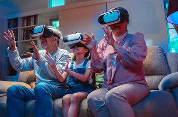 Happy family gamer of little granddaughter and grandparents in vr glasses playing video games enjoy virtual world in living room. Entertainment technology online together at home. - Powered by Adobe