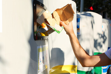 homme effectue le tri de ses déchets cartons et plastiques pour le recyclage - Acte citoyen