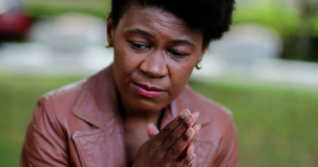 Troubled African woman praying to God seeking help and support