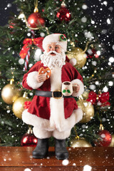 Fototapeta na wymiar Santa Claus decoration on a christmas tree blurry background. Christmas party.
