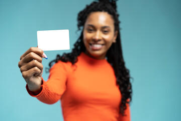 Young beautiful woman showing copy space on empty blank sign or gift card isolated on blue background