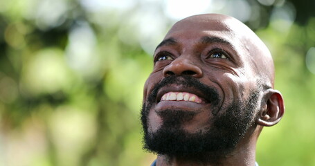 Satisfied African man smiling looking up. Confident black person