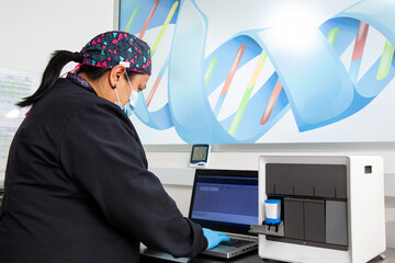 Female scientist working at the laboratory with a thermal cycler. Polymerase chain reaction...