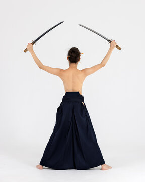 Aikido master woman in traditional samurai hakama kimono with black belt with sword, katana on white background. Healthy lifestyle and sports concept.